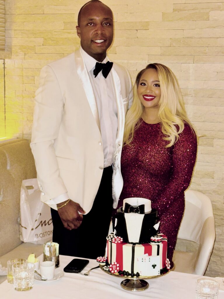 A woman and man posing in front of a cake.